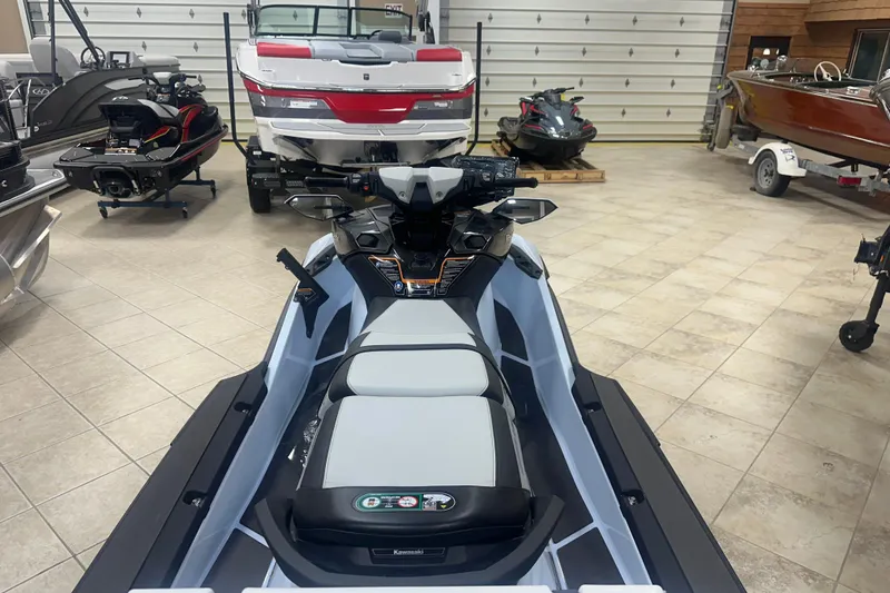 Slide: The Image of 2025 Kawasaki Ultra 160 LX-s Angler jet ski in showroom, surrounded by boats. - 4