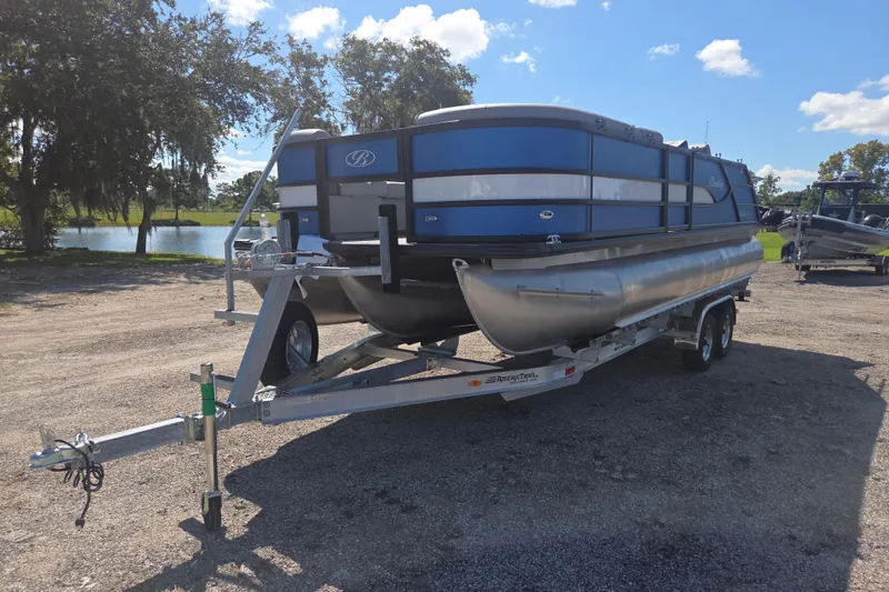 Slide: The Image of 2026 Bentley Pontoons 223 Swingback on trailer, parked outdoors under a clear blue sky. - 5