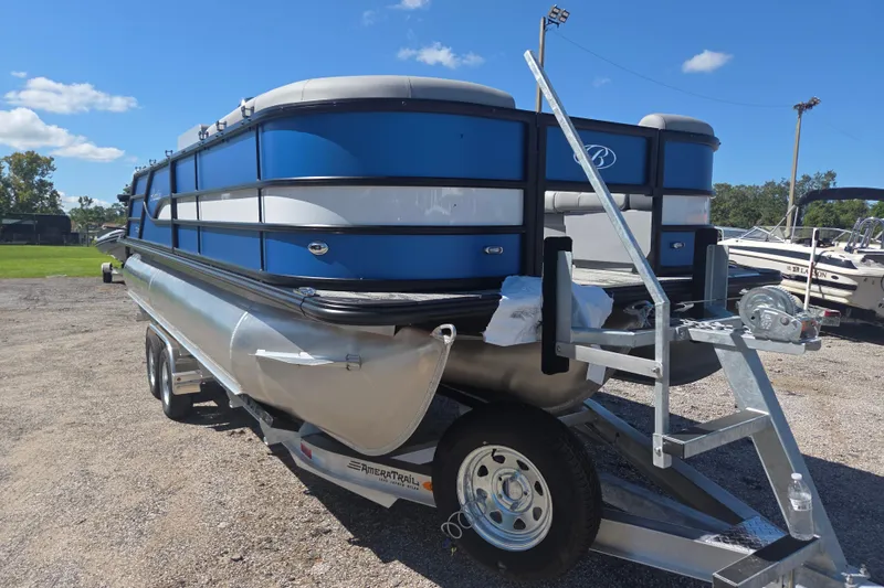 Slide: The Image of 2026 Bentley Pontoons 223 Swingback on trailer, blue and silver design, parked outdoors. - 6