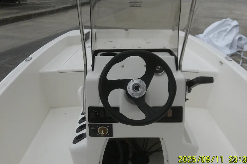 Slide: The Image of 2025 Mako Pro Skiff 17 CC boat console with steering wheel and controls. - 14