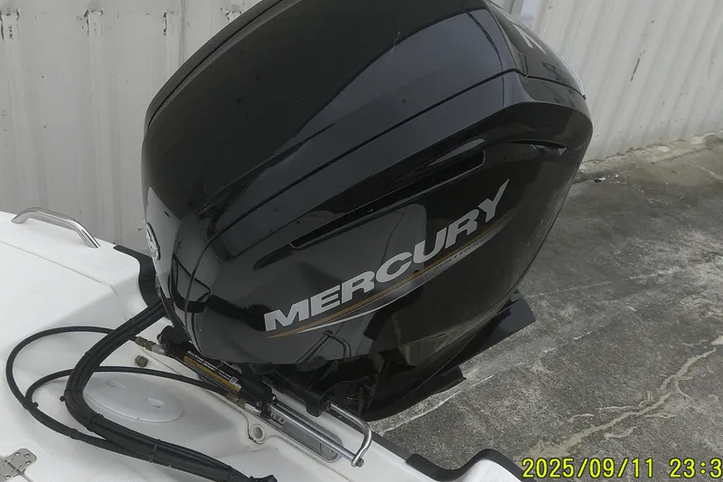 Slide: The Image of 2025 Mako Pro Skiff 17 CC with Mercury outboard motor, docked on concrete surface. - 18