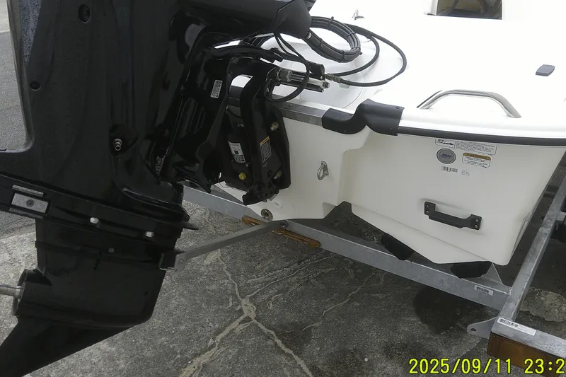 Slide: The Image of 2025 Mako Pro Skiff 17 CC boat on trailer, showing motor and stern details. - 24