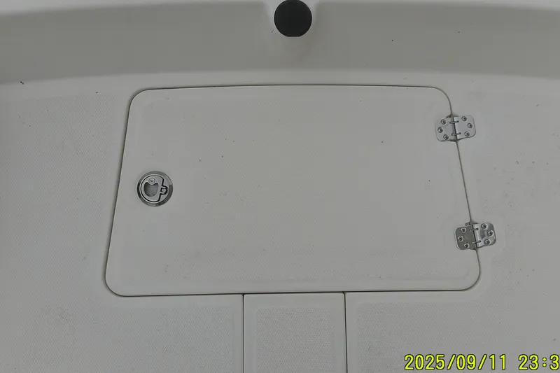 Slide: The Image of Hatch cover on 2025 Mako Pro Skiff 17 CC boat deck, featuring hinges and latch. - 5
