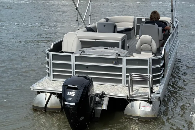 Slide: The Image of 2025 Berkshire 24RFC LE 2.75 pontoon boat parked in a lot under clear blue sky. - 5