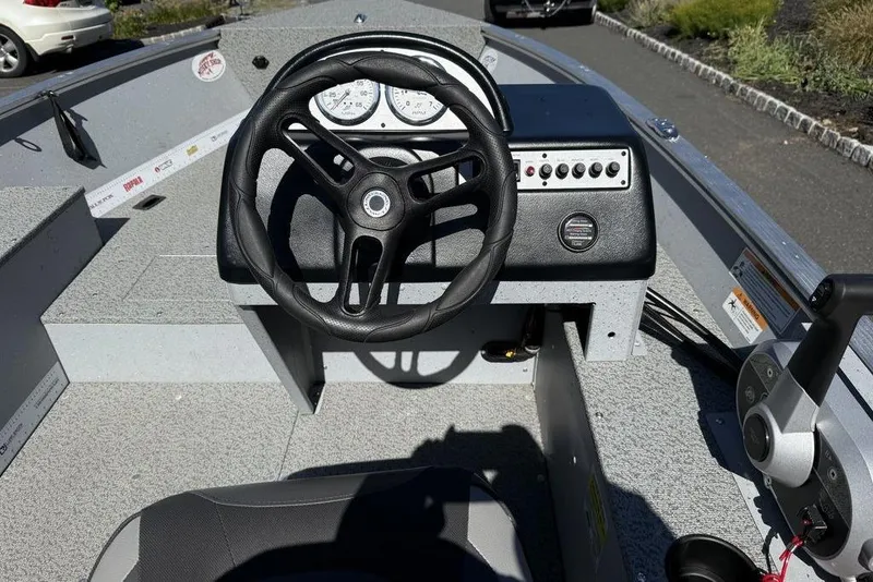 Slide: The Image of 2023 Lund 1400 Fury SS boat dashboard with steering wheel and control panel. - 4