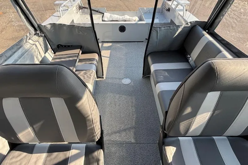 Slide: The Image of Interior of 2025 Hewescraft 180 Sportsman boat with gray seating and spacious layout. - 7