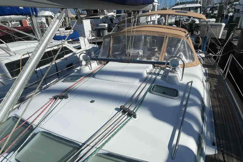 Slide: The Image of 2004 Beneteau Oceanis 473 sailboat docked, showcasing deck and rigging details. - 100