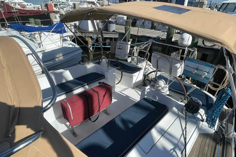 Slide: The Image of 2004 Beneteau Oceanis 473 sailboat cockpit with seating and canopy in marina. - 101