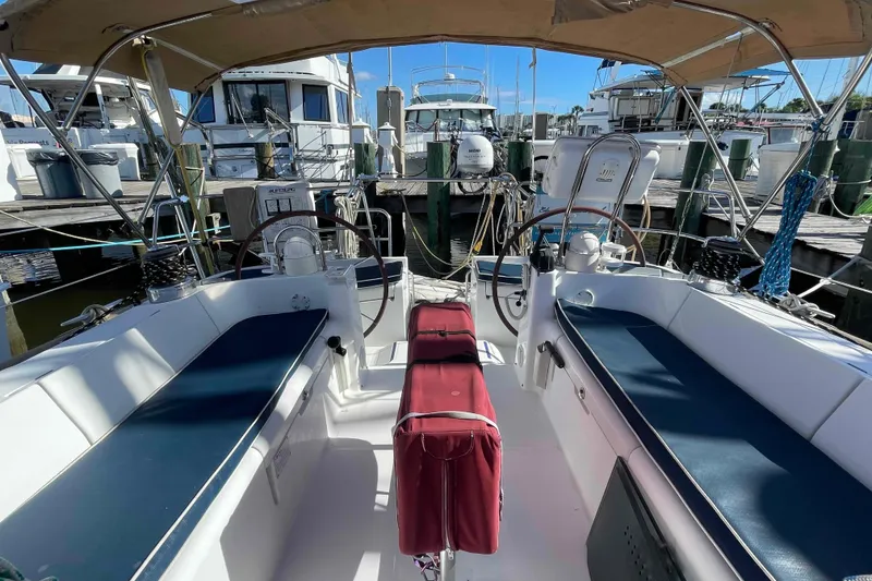 Slide: The Image of Cockpit of 2004 Beneteau Oceanis 473 sailboat docked at marina, featuring dual steering wheels. - 103