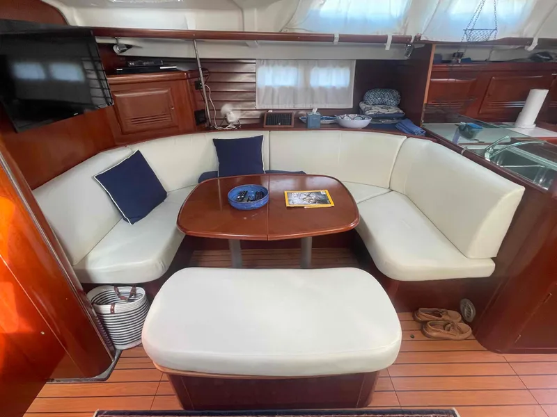 Slide: The Image of Interior of 2004 Beneteau Oceanis 473 yacht with cozy seating and wooden finishes. - 15