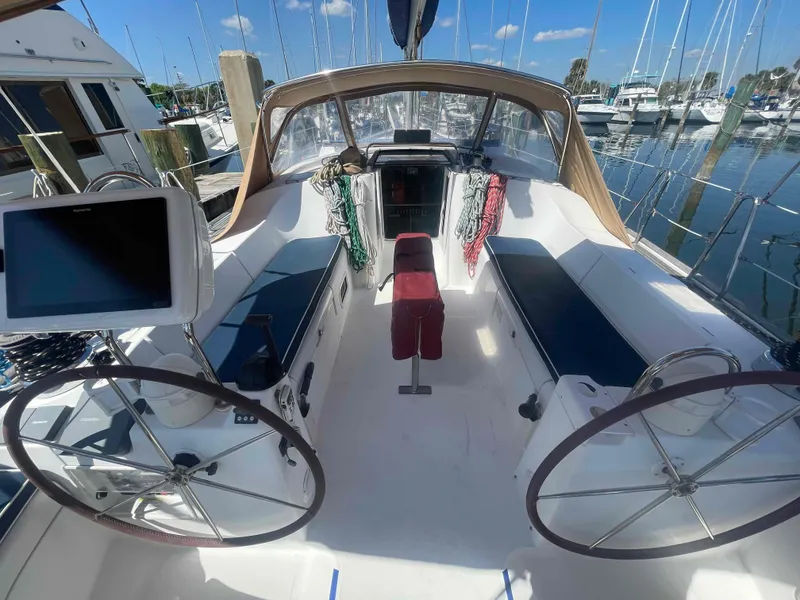 Slide: The Image of 2004 Beneteau Oceanis 473 sailboat cockpit with dual steering wheels, docked at marina. - 2