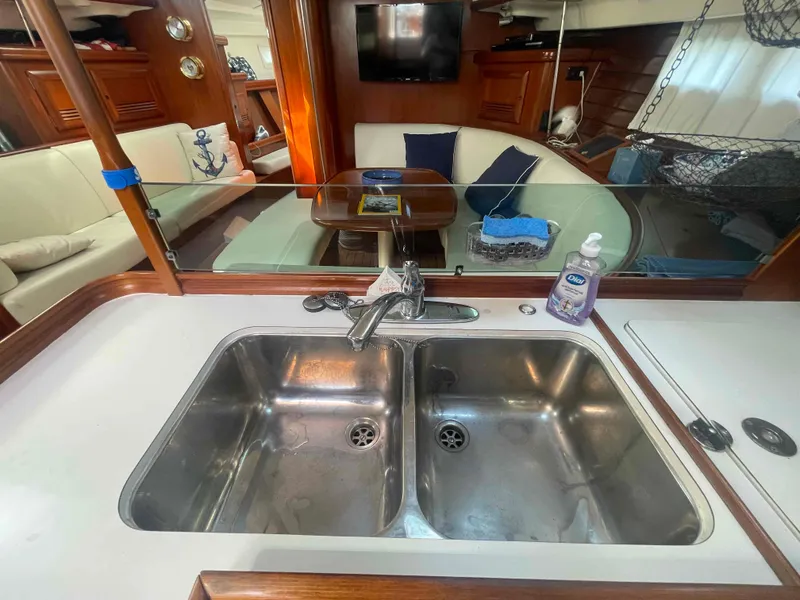 Slide: The Image of Interior of 2004 Beneteau Oceanis 473 yacht with kitchen sink and cozy seating area. - 21
