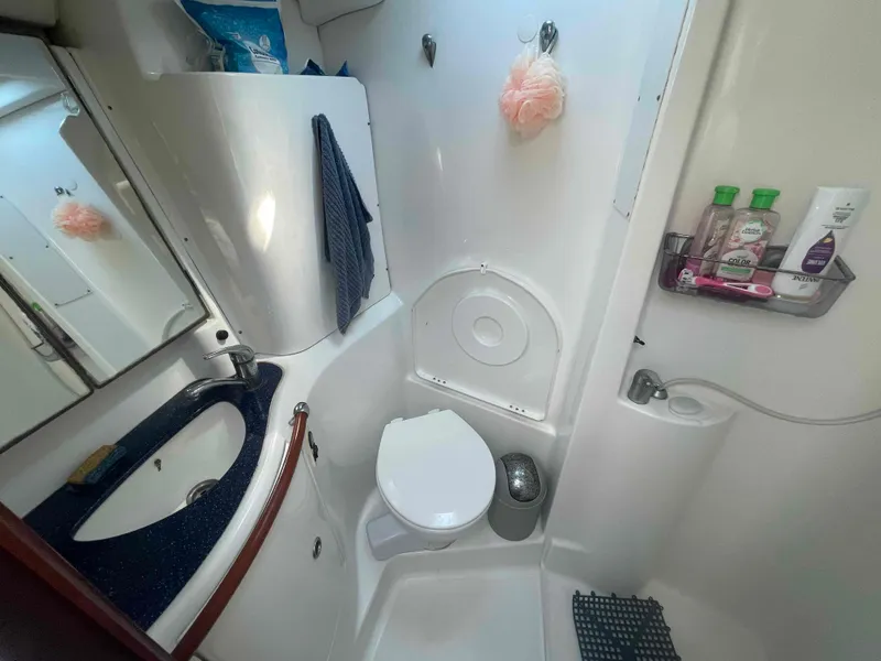 Slide: The Image of 2004 Beneteau Oceanis 473 bathroom with sink, toilet, and toiletries. - 8