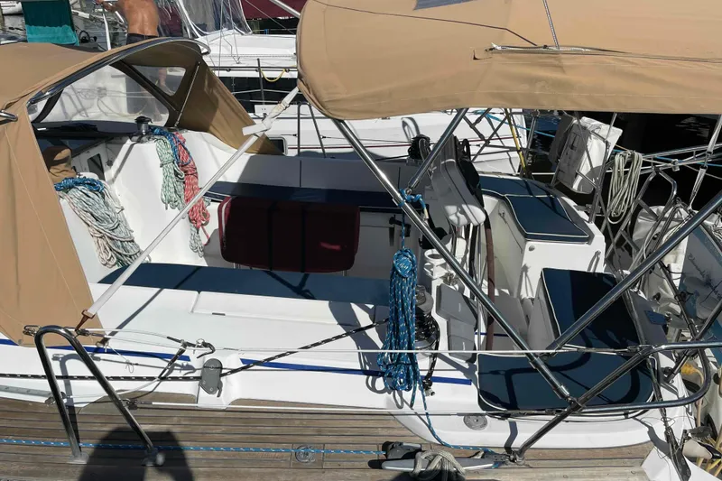 Slide: The Image of 2004 Beneteau Oceanis 473 sailboat cockpit with tan canopy and neatly coiled ropes. - 81