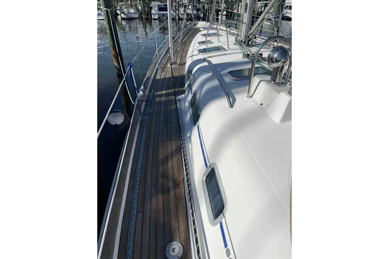 Slide: The Image of 2004 Beneteau Oceanis 473 sailboat deck with wooden finish and marina view. - 95