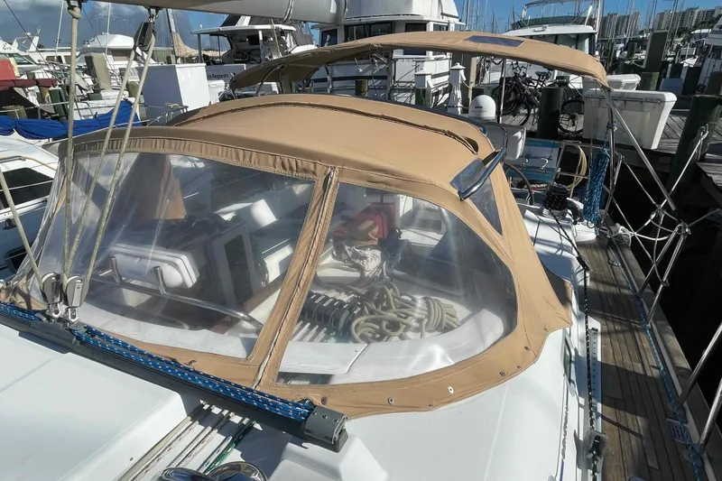 Slide: The Image of 2004 Beneteau Oceanis 473 sailboat with tan canopy docked at marina. - 97