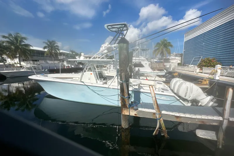 Slide: The Image of 2017 Sea Hunter 39 boat docked at marina with palm trees and blue sky. - 12