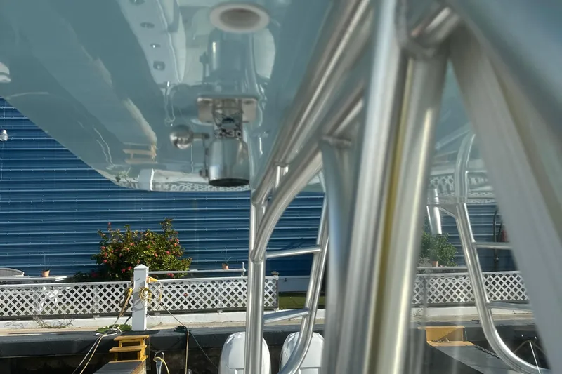 Slide: The Image of 2017 Sea Hunter 39 boat with stainless steel framework and blue hull, docked near a blue building. - 18