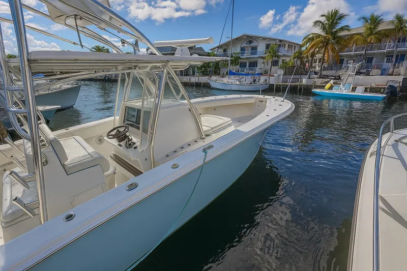 Slide: The Image of 2017 Sea Hunter 39 boat docked in a marina with palm trees and buildings. - 9