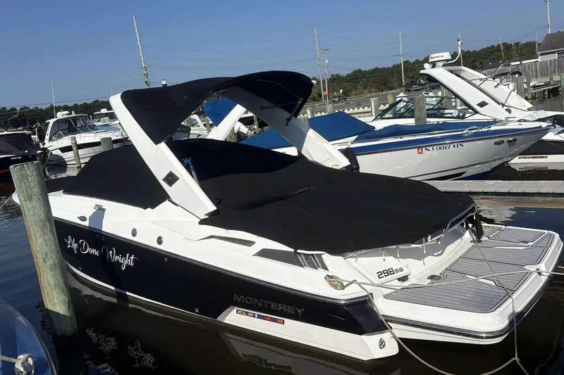 The Image of 2016 Monterey 298SS Super Sport boat docked with black cover, side view. - 1