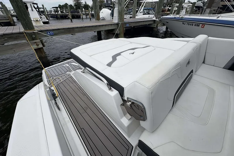 Slide: The Image of 2016 Monterey 298SS Super Sport boat docked, featuring sleek white seating and deck design. - 14