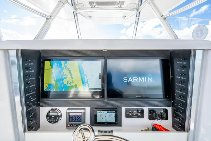 Slide: The Image of Control panel of a 2011 Bahama 37 boat with navigation screens and switches. - 13