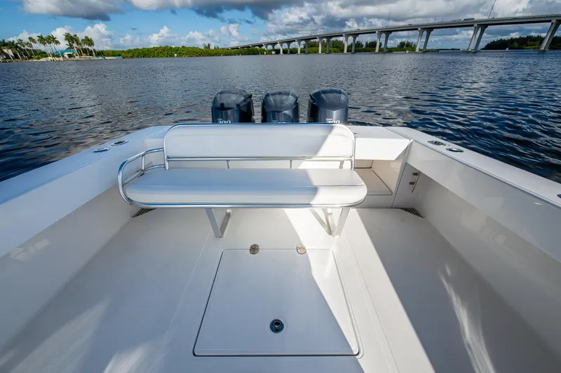 Slide: The Image of 2011 Bahama 37 boat with bench seating, triple engines, and scenic waterway view. - 16