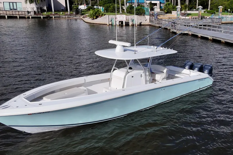 Slide: The Image of 2011 Bahama 37 boat with triple engines docked on calm water. - 2