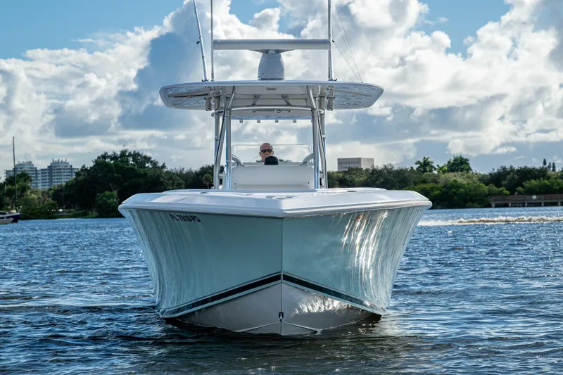 Slide: The Image of 2011 Bahama 37 boat cruising on a sunny day with scenic waterfront backdrop. - 3