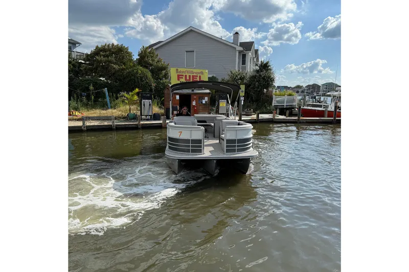 Slide: The Image of 2025 Berkshire 24CL 2.75 LE pontoon boat on trailer in parking lot. - 2