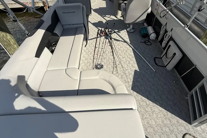 Slide: The Image of 2025 Berkshire 24CL 2.75 LE pontoon boat with outboard motor, parked on asphalt. - 7