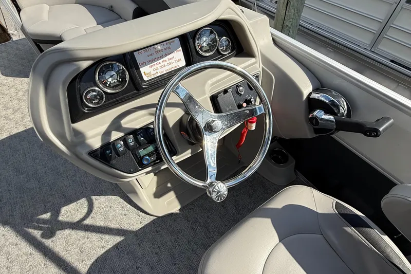 Slide: The Image of 2025 Berkshire 24CL 2.75 LE pontoon boat with Mercury outboard motor in parking lot. - 8