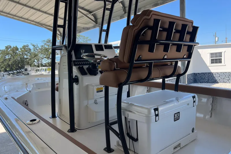 Slide: The Image of 2026 Key West 230 Bay Reef boat interior with seating and cooler under a canopy. - 11