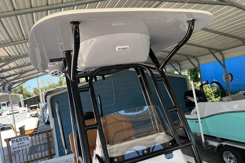 Slide: The Image of 2026 Key West 230 Bay Reef boat under a metal canopy, showcasing its T-top and seating. - 18