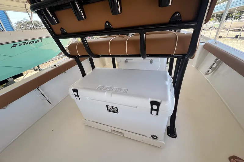 Slide: The Image of 2026 Key West 230 Bay Reef boat interior with cooler and seating. - 26