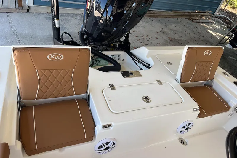 Slide: The Image of 2026 Key West 230 Bay Reef boat interior with tan cushioned seats and storage compartments. - 29
