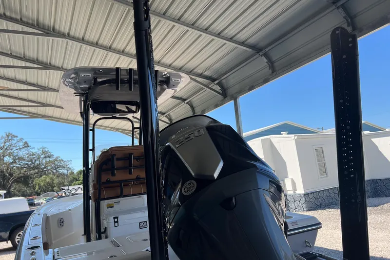 Slide: The Image of 2026 Key West 230 Bay Reef boat under a metal canopy, showcasing its engine and seating. - 9