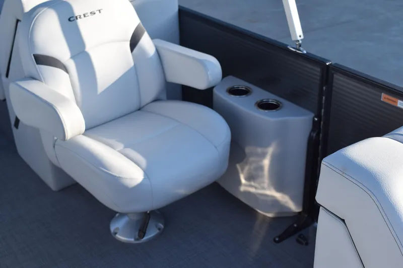 Slide: The Image of 2024 Crest Classic LX 220 SLC boat interior with plush seating and cup holders. - 14
