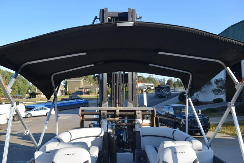 Slide: The Image of 2024 Crest Classic LX 220 SLC boat with canopy, parked outdoors. - 15