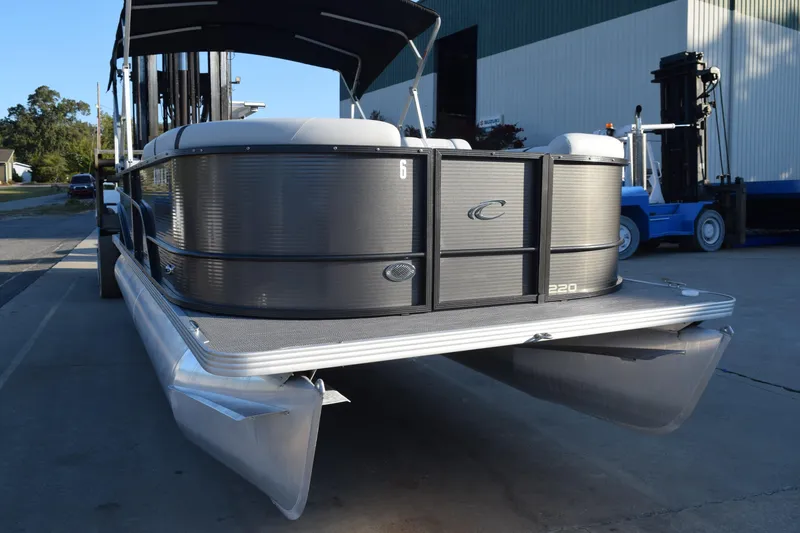Slide: The Image of 2024 Crest Classic LX 220 SLC pontoon boat, docked, showcasing sleek design and modern features. - 3