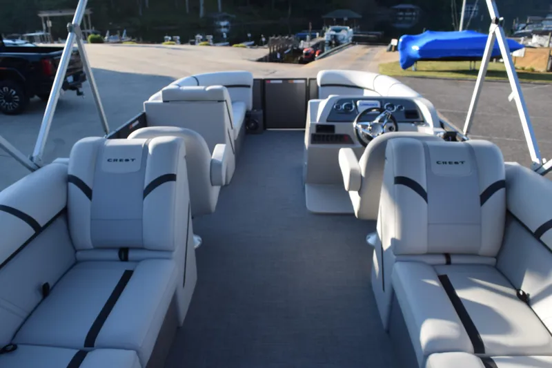 Slide: The Image of 2024 Crest Classic LX 220 SLC pontoon boat with spacious seating and modern helm. - 7