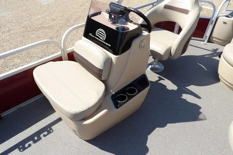 Slide: The Image of 2018 Sun Tracker BASS BUGGY® 18 DLX boat interior with beige seating and steering console. - 18