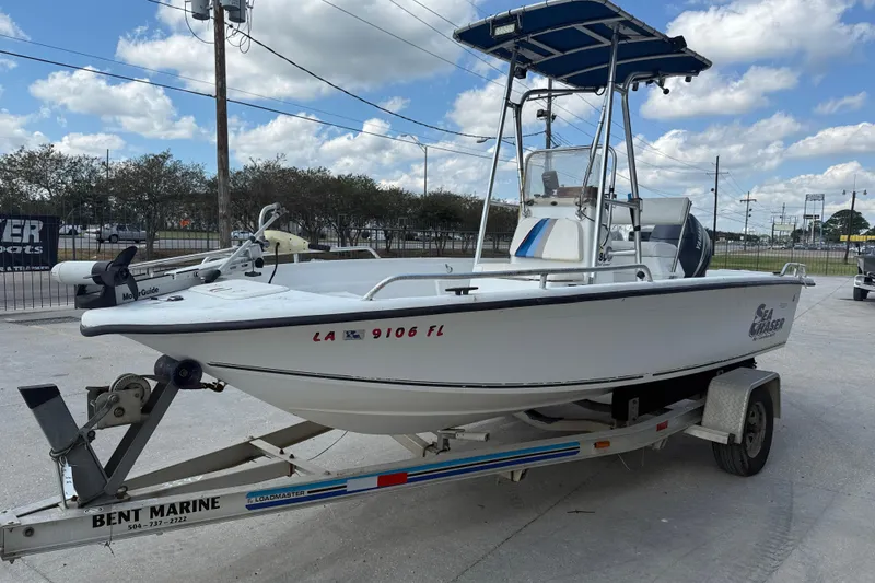 Slide: The Image of 2005 Sea Chaser 1800 RG boat on trailer, parked outdoors under blue sky. - 4