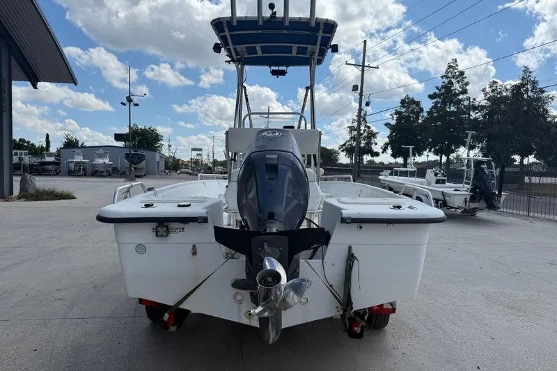 Slide: The Image of 2005 Sea Chaser 1800 RG boat with outboard motor, parked outdoors under a cloudy sky. - 6