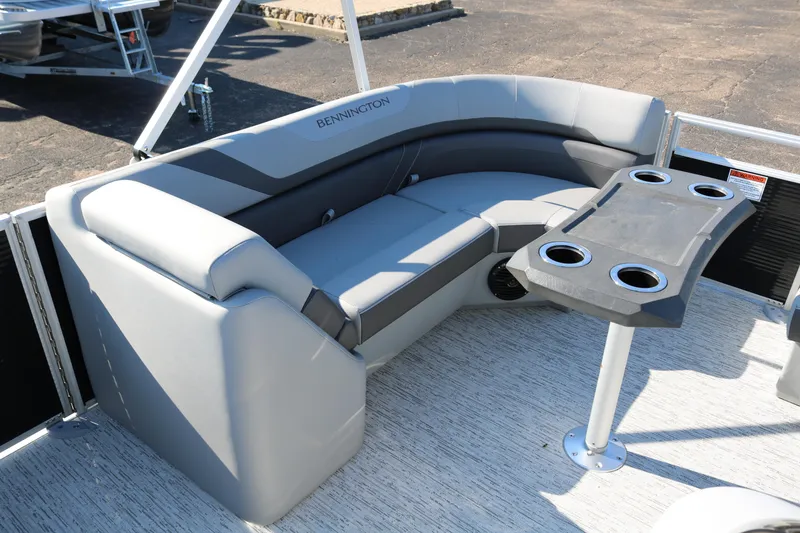 Slide: The Image of 2026 Bennington 22SX Stern Radius boat with gray seating and cupholder table. - 12