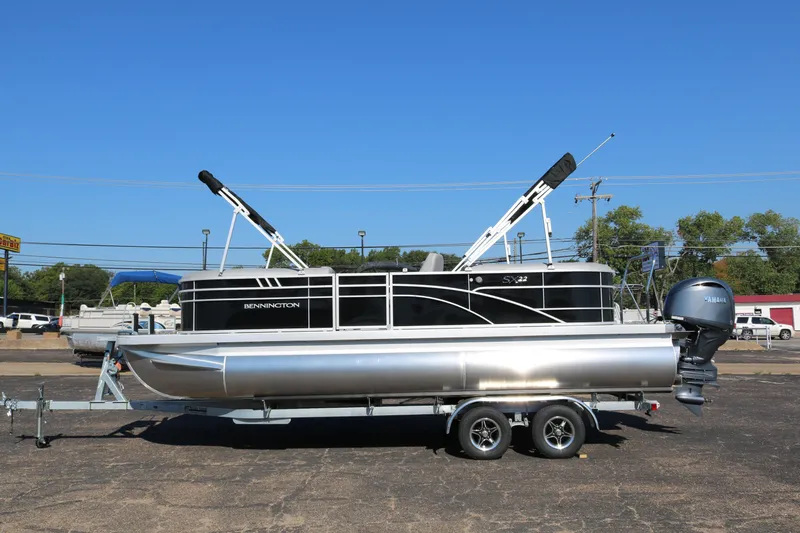 Slide: The Image of 2026 Bennington 22SX Stern Radius pontoon boat on trailer, clear blue sky background. - 4