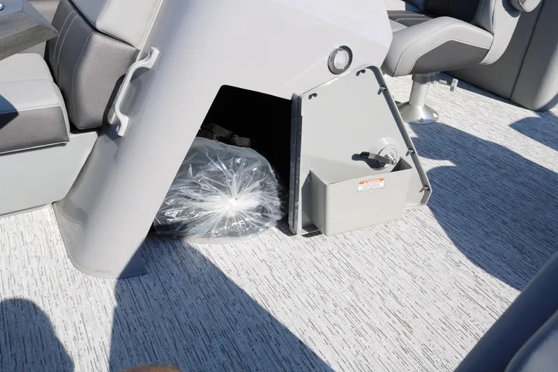 Slide: The Image of 2026 Bennington 22SX Stern Radius boat interior storage compartment with gray seating. - 41
