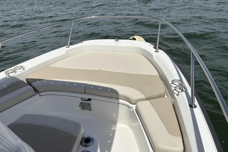 Slide: The Image of 2017 Boston Whaler 210 Dauntless boat interior with cushioned seating on open water. - 2