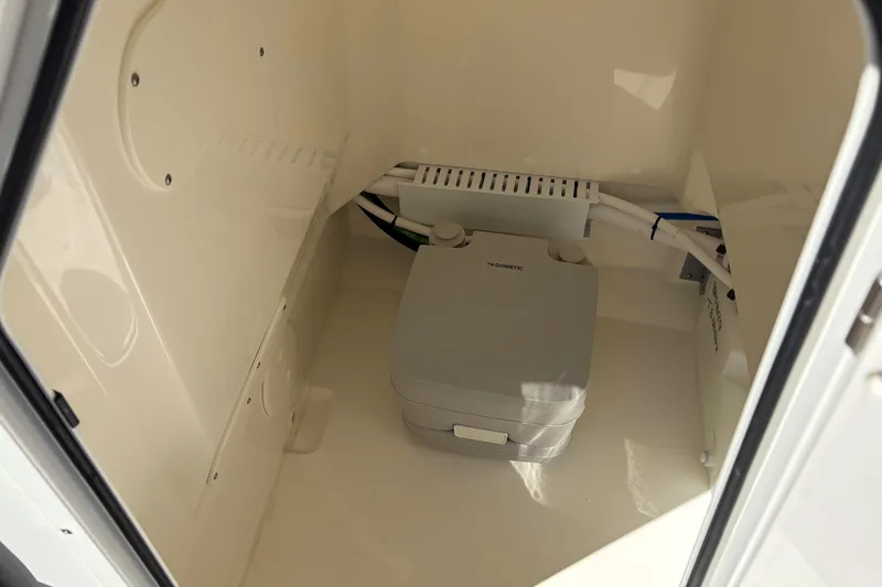 Slide: The Image of 2024 Boston Whaler 210 Montauk interior with compact marine toilet. - 11