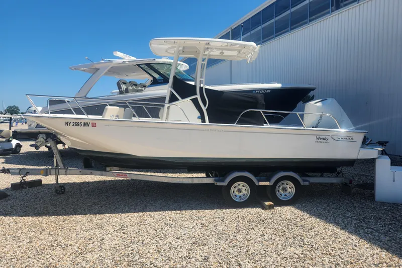 Slide: The Image of 2024 Boston Whaler 210 Montauk boat on trailer, parked outdoors. - 15